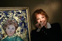 Lisa Donovan stands with her portrait, by Edna Hibel